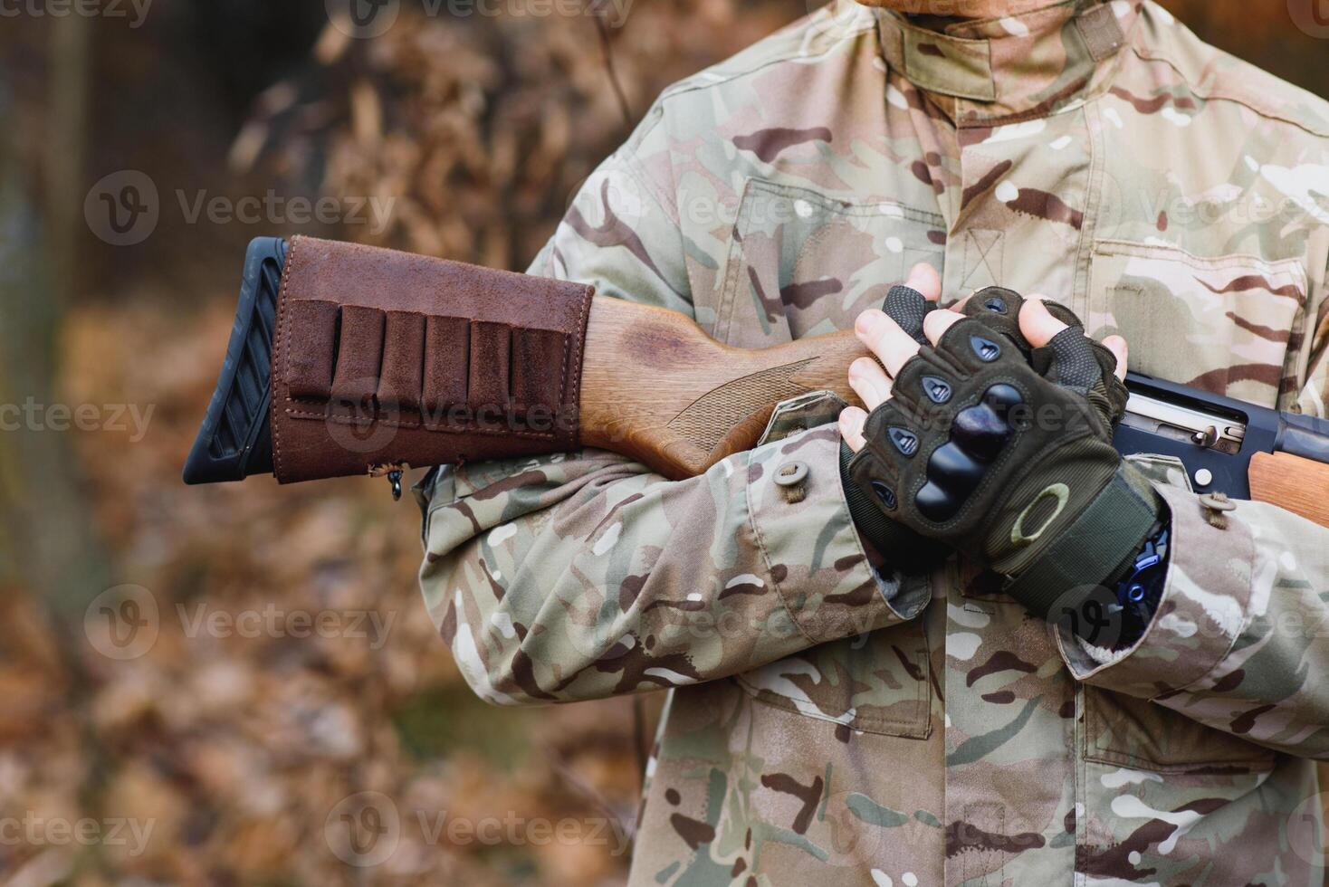 chasseur Beau gars avec arme. chasseur dépenser loisir chasse. chasse équipement. brutal masculin passe-temps. homme observer la nature Contexte. chasseur tenir fusil. sécurité mesures. Naturel environnement photo