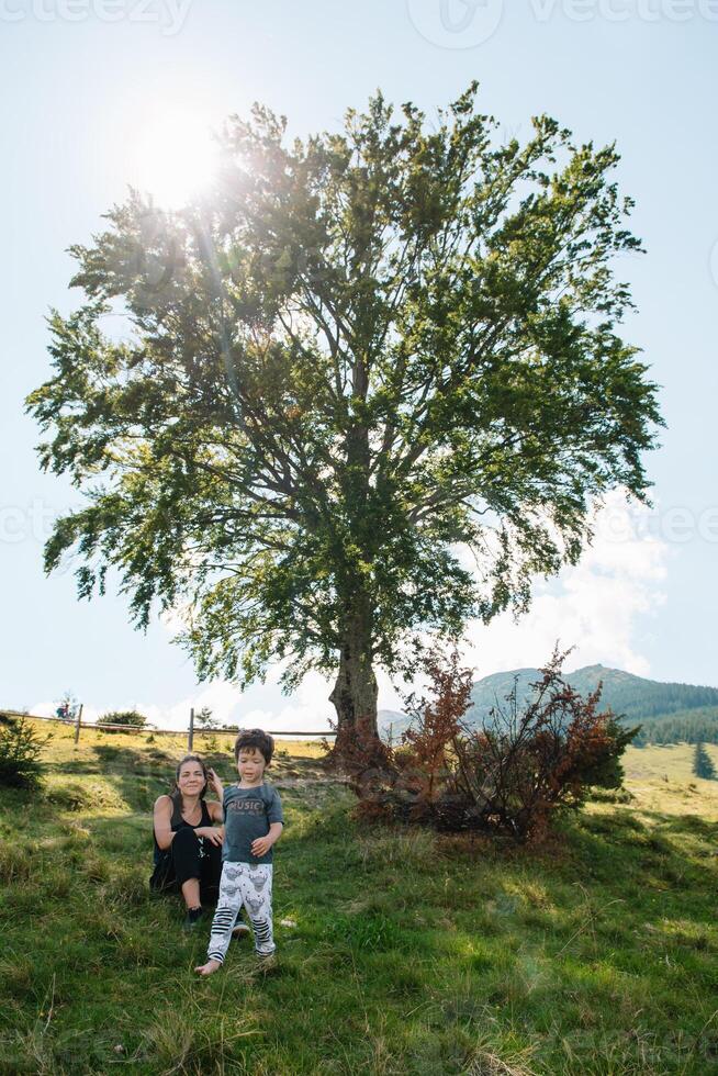 Jeune maman avec bébé garçon en voyageant. mère sur randonnée aventure avec enfant, famille voyage dans montagnes. nationale parc. une randonnée avec les enfants. actif été vacances. fisheye lentille. photo