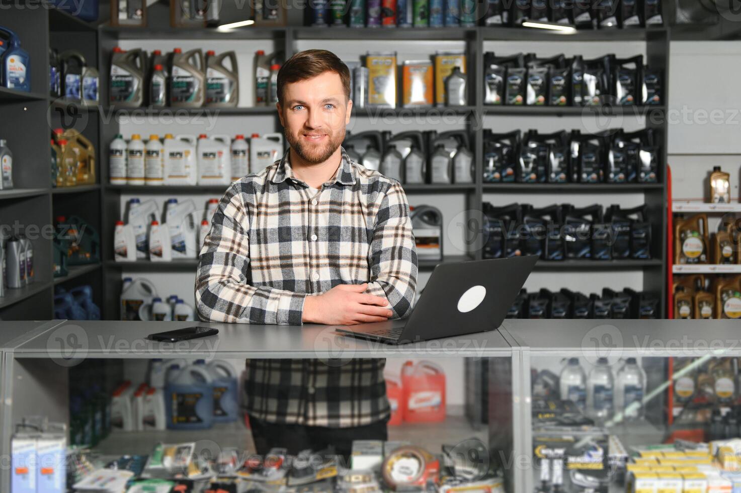 portrait de une Beau vendeur dans un auto les pièces magasin. le concept de voiture réparation photo