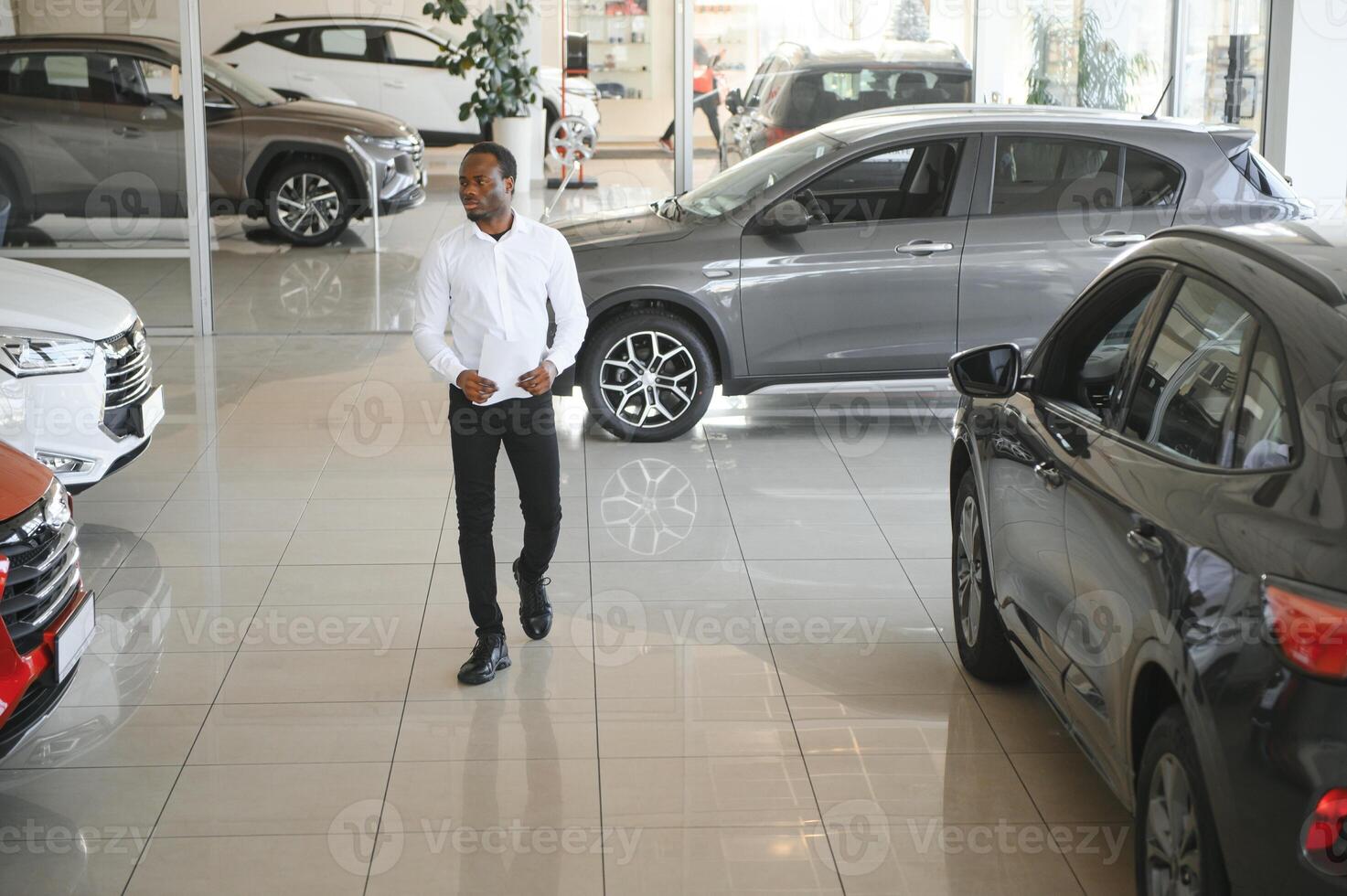 Jeune africain américain voiture concession principal permanent dans véhicule salle d'exposition photo