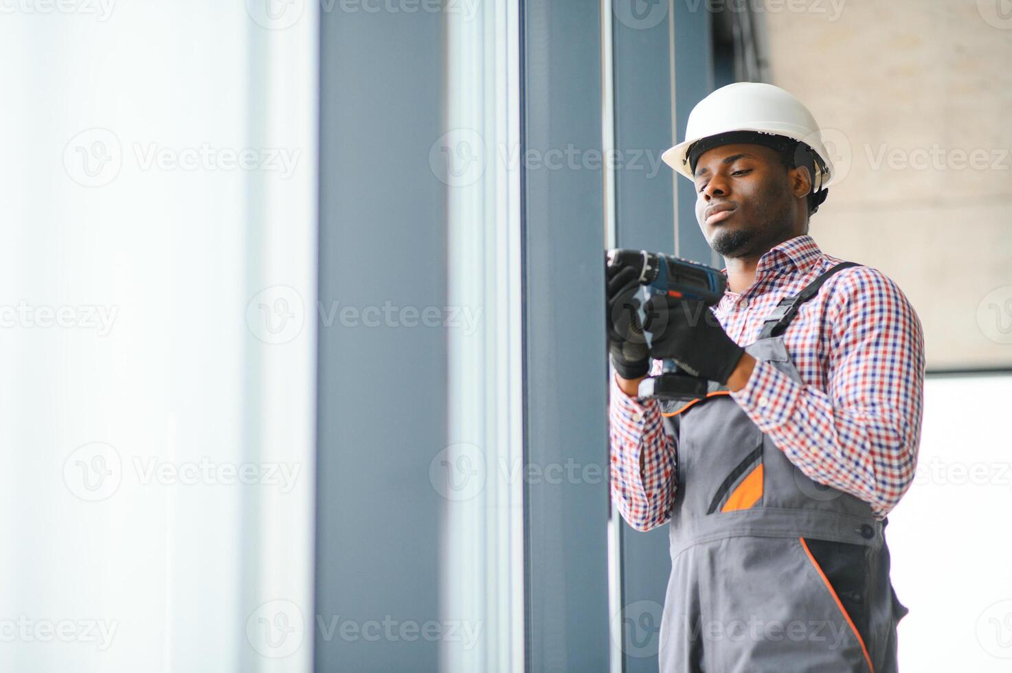 construction africain ouvrier réparer Plastique fenêtre avec Tournevis à l'intérieur, espace pour texte. bannière conception photo