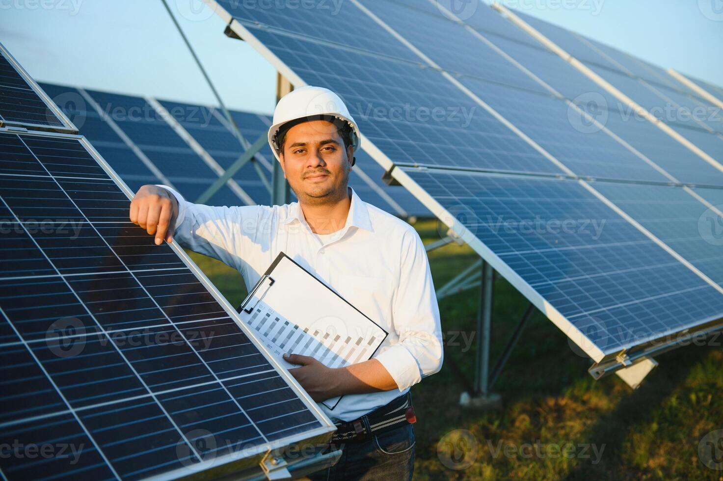 portrait Jeune Indien technicien ou directeur portant formel chiffons permanent avec solaire panneau. renouvelable énergie, homme permanent franchi bras, copie espace photo