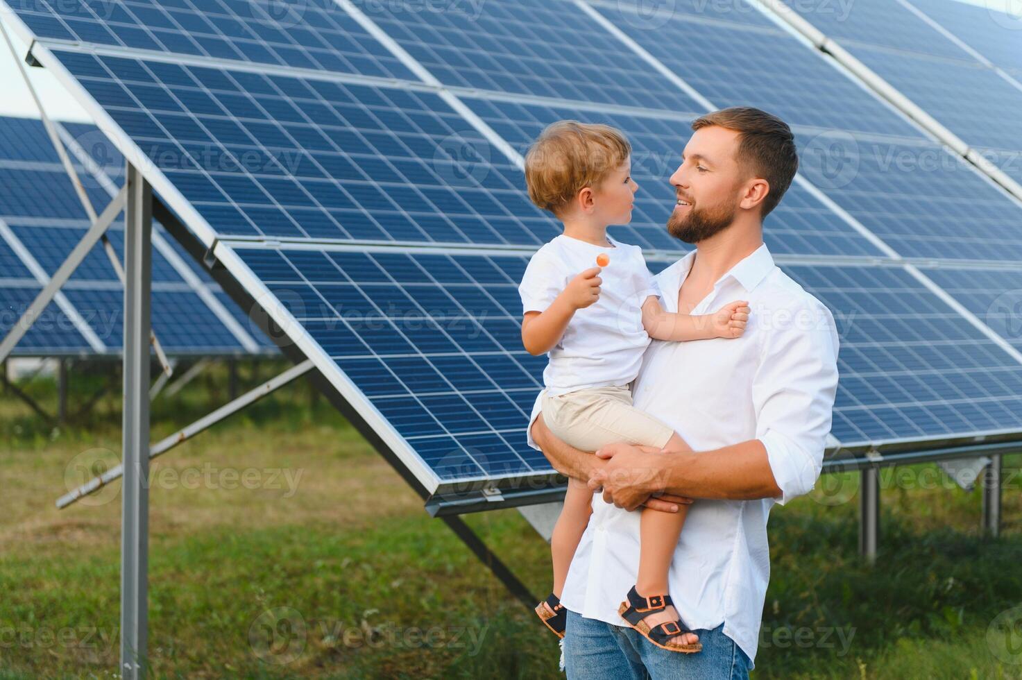 homme montrant peu enfant le solaire panneaux pendant ensoleillé journée. père en présentant à le sien enfant moderne énergie Ressource. peu pas à alternative énergie. photo