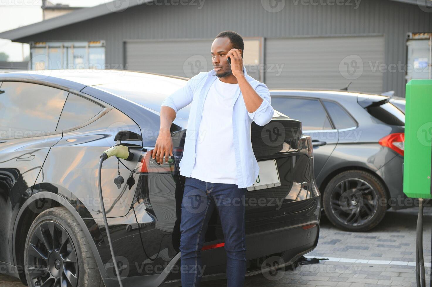 homme bouchage dans électrique voiture à l'extérieur Bureau dans voiture parc mise en charge photo