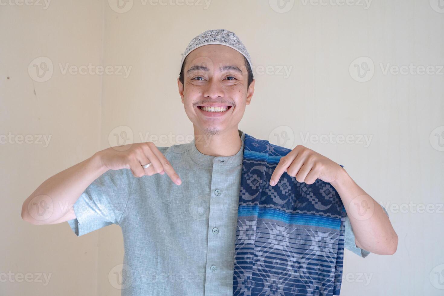 musulman asiatique homme montrer du doigt le lien geste lorsque Ramadan fête. le photo est adapté à utilisation pour ramadhan affiche et musulman contenu médias.