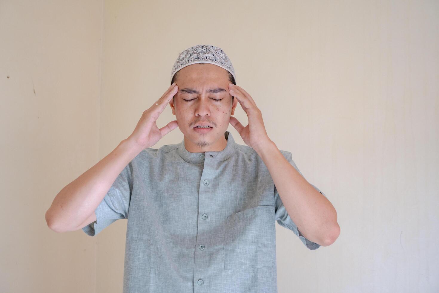 musulman asiatique homme étourdi et mal de crâne visage lorsque Ramadan fête. le photo est adapté à utilisation pour ramadhan affiche et musulman contenu médias.