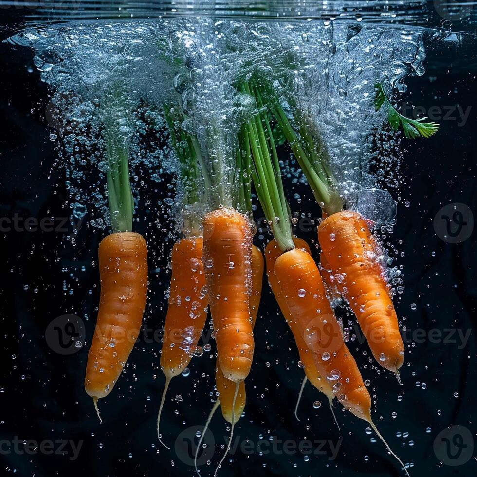 carottes chute dans l'eau avec éclaboussure sur noir Contexte. photo