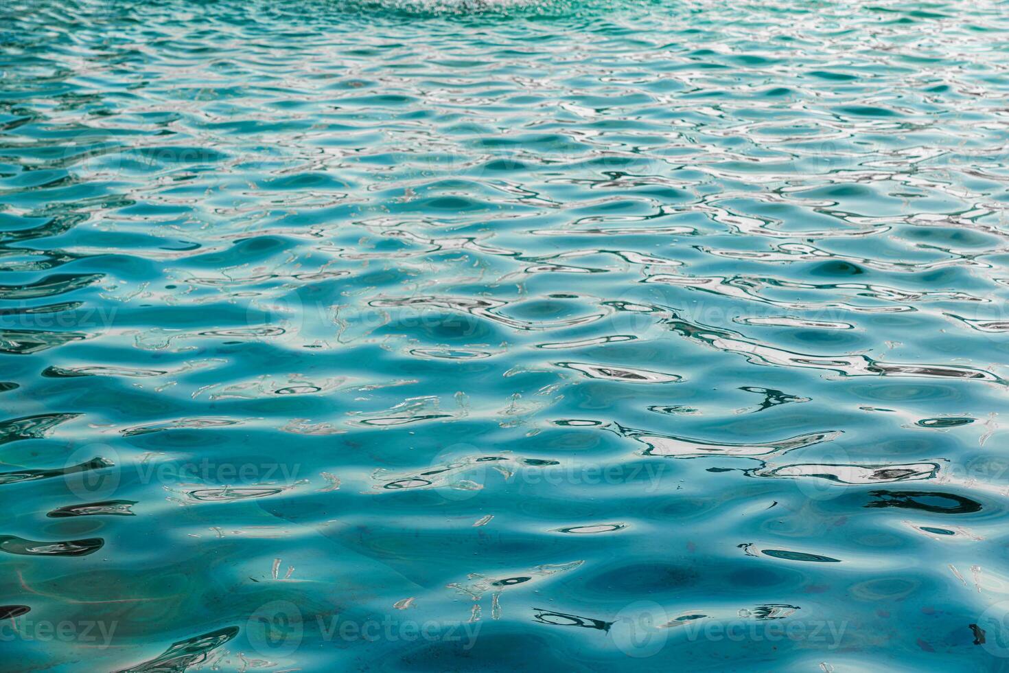 le texture de le vagues dans turquoise couleur, illuminé par le Soleil à le coucher du soleil ou aube. la nature Contexte. photo