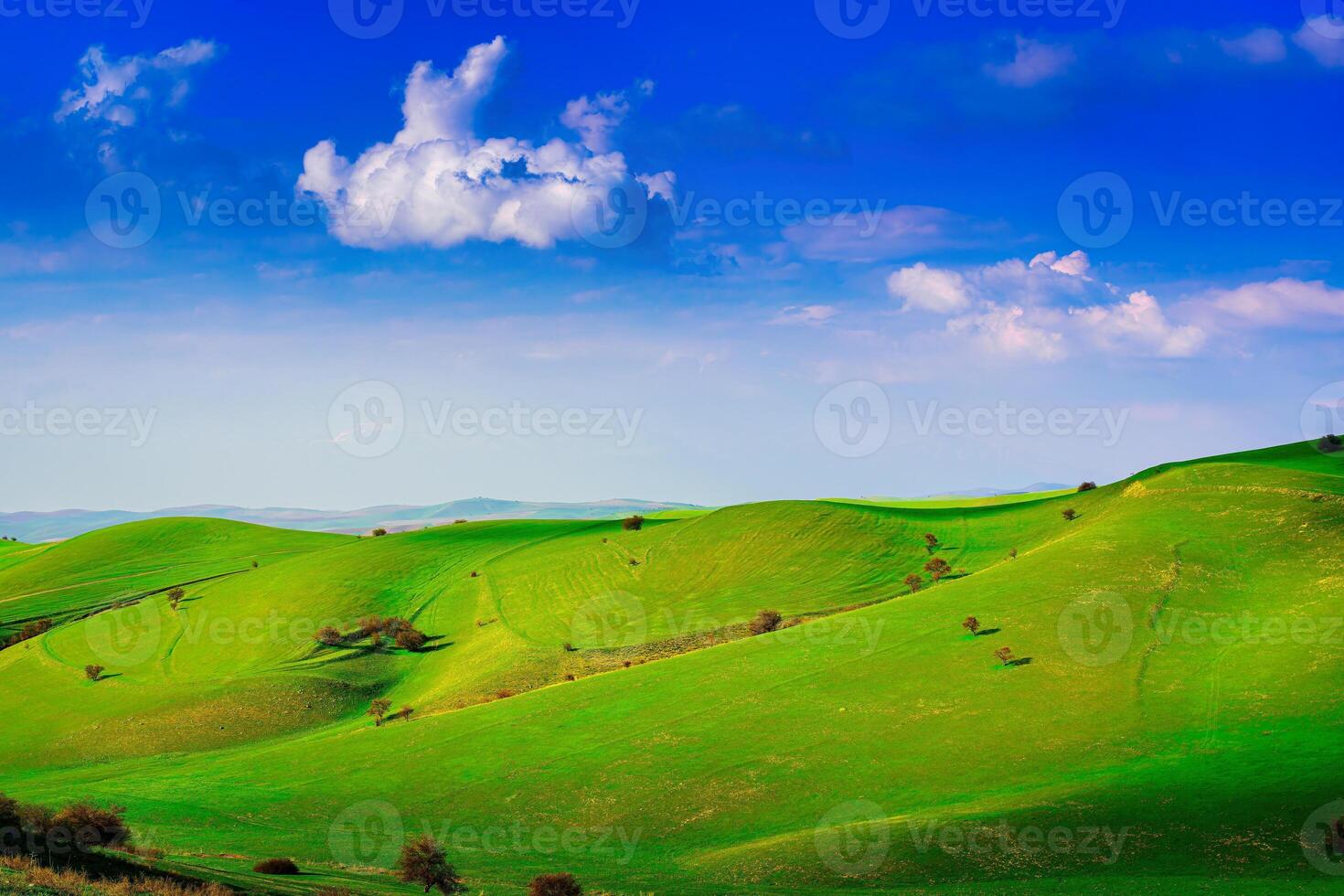 collines et montagnes couvert avec Jeune vert herbe et illuminé par le Soleil sur une ensoleillé journée. photo
