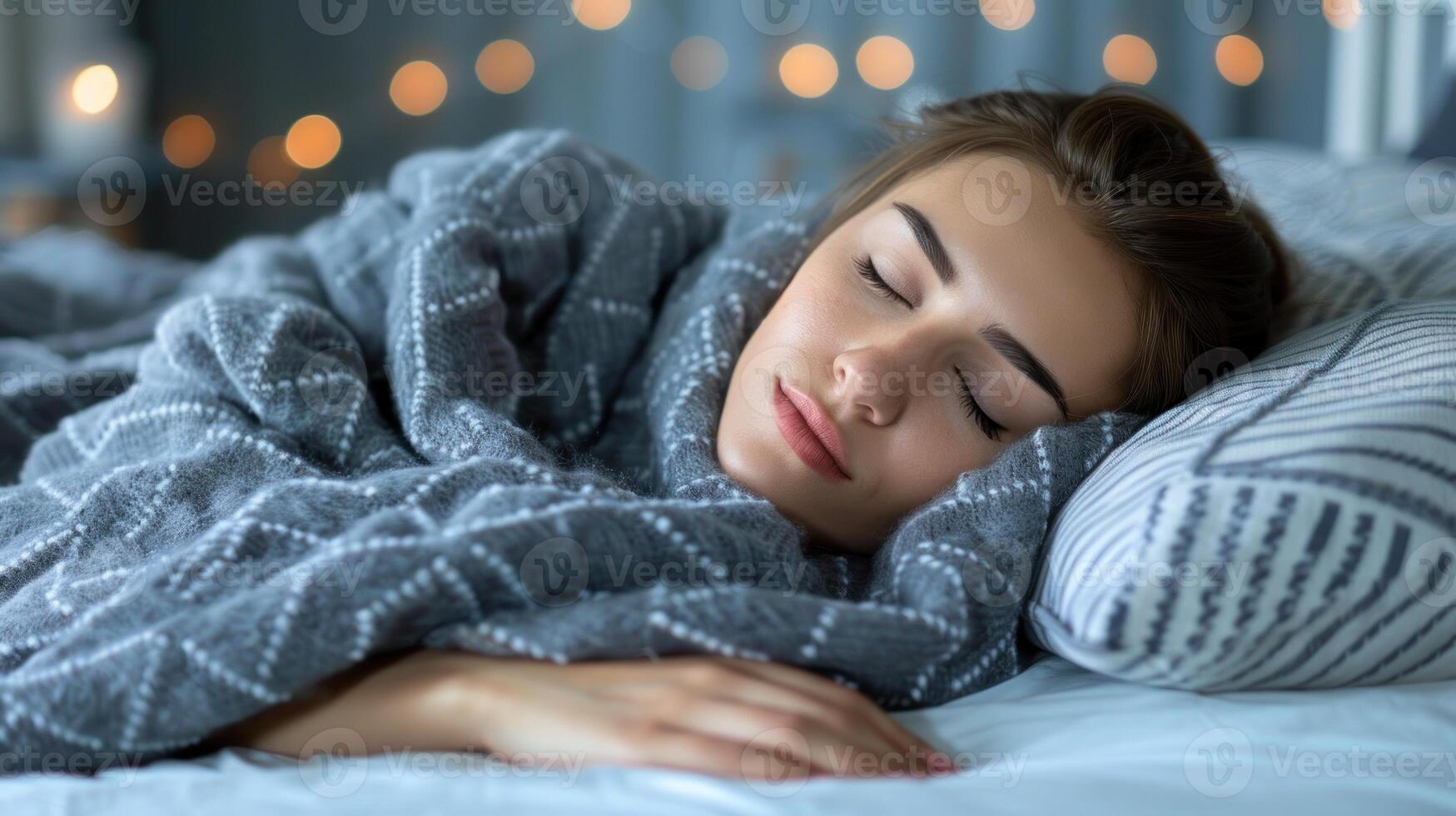 une femme pacifiquement dort en dessous de une confortable couverture sur une lit photo