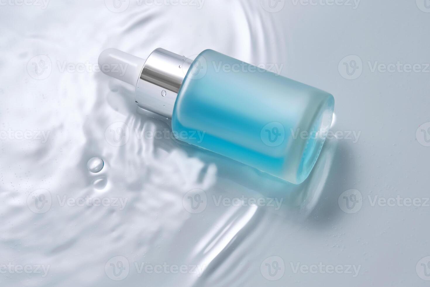 bouteilles de produits de beauté avec une compte-gouttes dans l'eau sur une bleu Contexte. photo