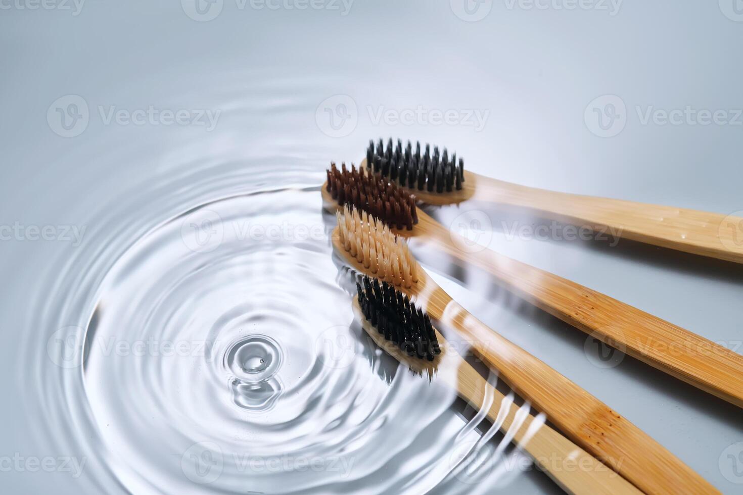 Naturel bambou brosses à dents dans l'eau sur une bleu Contexte. photo