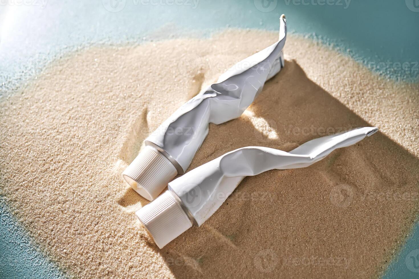 deux tubes de crème sur le sable. photo