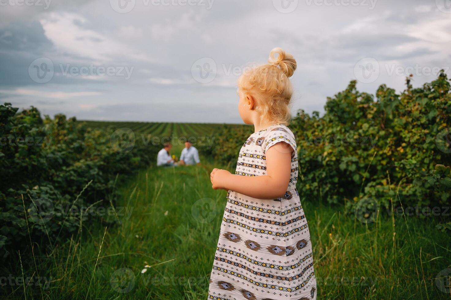 content famille en marchant dans le parc. maman, papa et fille marcher en plein air, Parents en portant le bébé les filles mains. enfance, la parentalité, famille obligations, mariage concept. photo