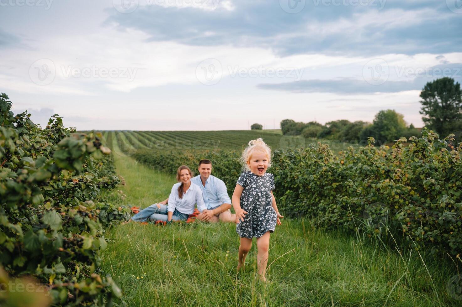 content famille en marchant dans le parc. maman, papa et fille marcher en plein air, Parents en portant le bébé les filles mains. enfance, la parentalité, famille obligations, mariage concept. photo