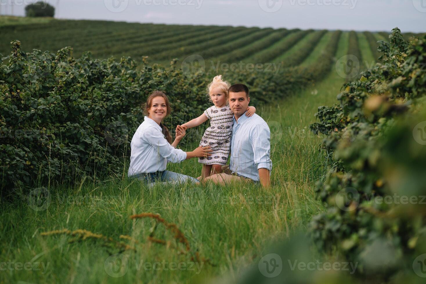 content famille en marchant dans le parc. maman, papa et fille marcher en plein air, Parents en portant le bébé les filles mains. enfance, la parentalité, famille obligations, mariage concept. photo