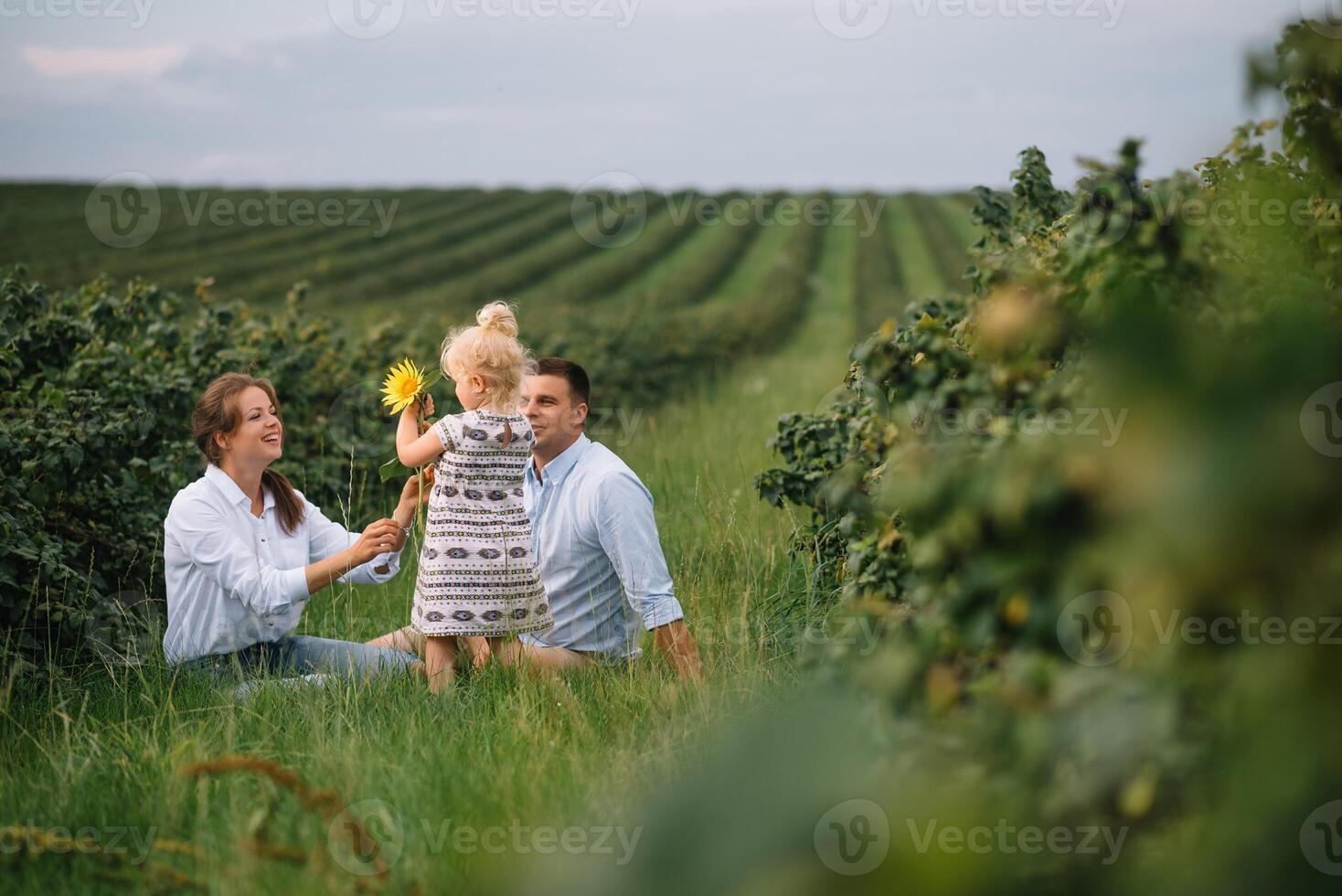 content famille en marchant dans le parc. maman, papa et fille marcher en plein air, Parents en portant le bébé les filles mains. enfance, la parentalité, famille obligations, mariage concept. photo