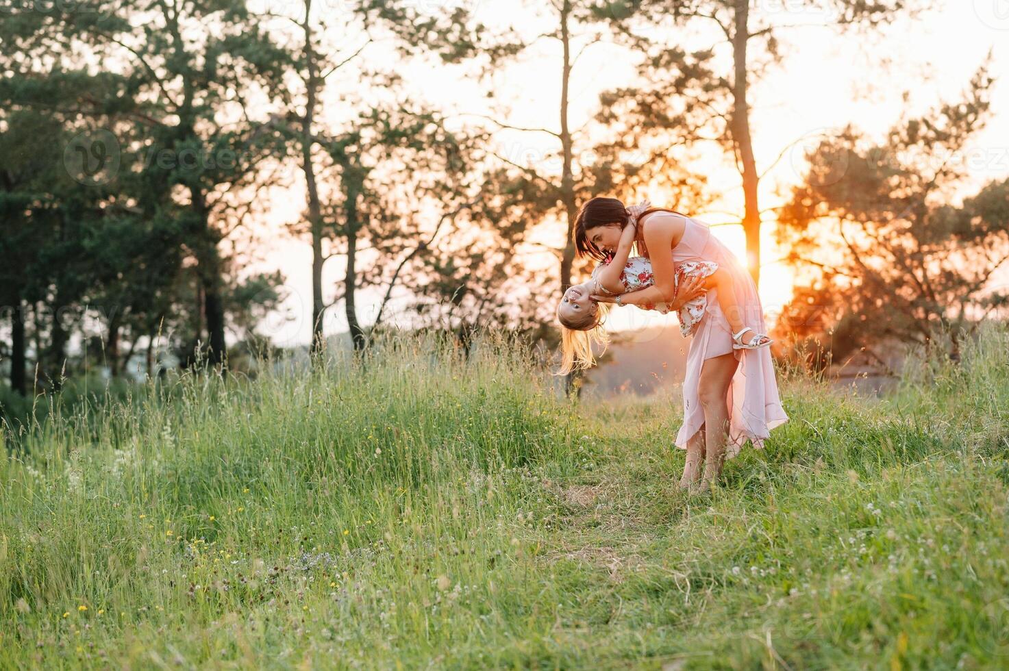 élégant mère et Beau fille ayant amusement sur le la nature. content famille concept. beauté la nature scène avec famille Extérieur mode de vie. famille repos ensemble. bonheur dans famille vie. les mères journée. photo