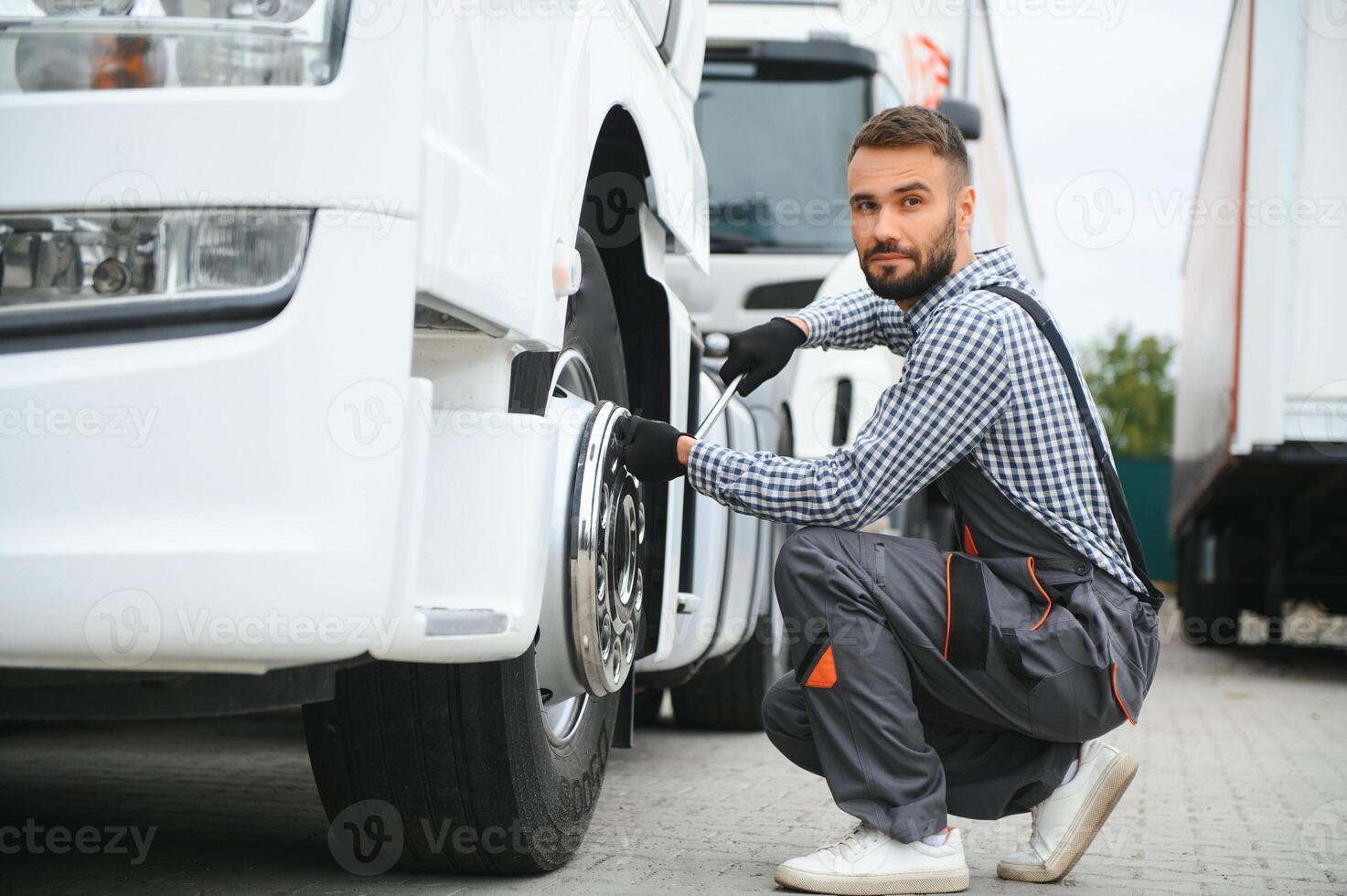 travail avec endommagé pneu. Jeune un camion chauffeur est avec le sien véhicule à jour photo