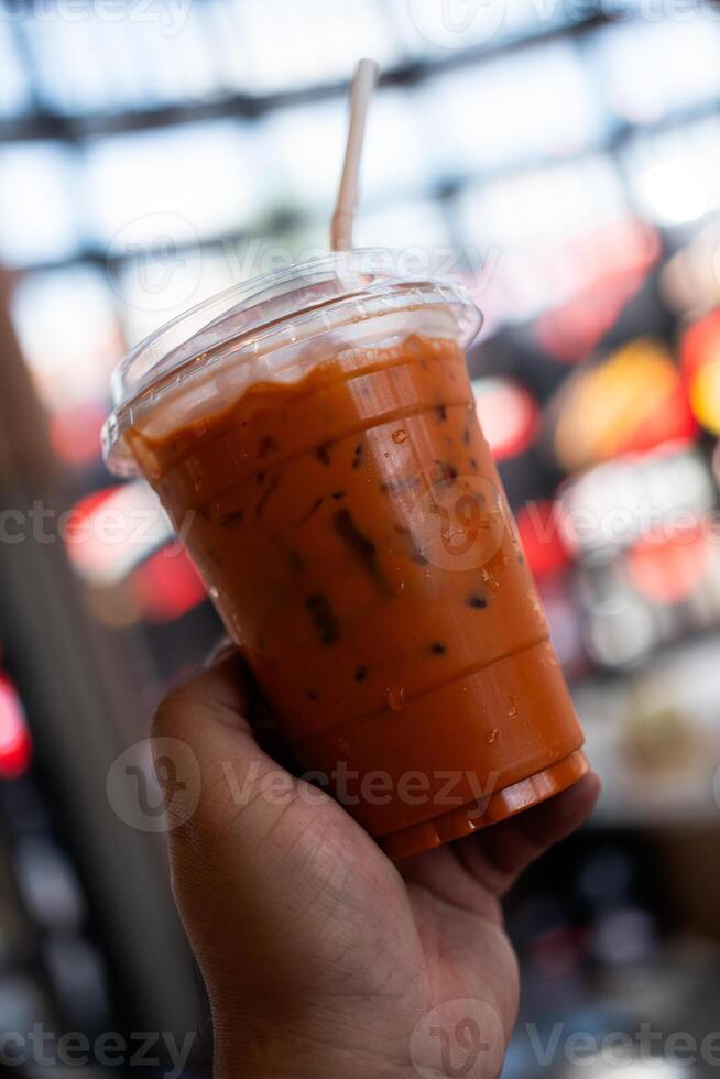 une tasse de le la glace thaïlandais Lait thé avec une Plastique tube. photo