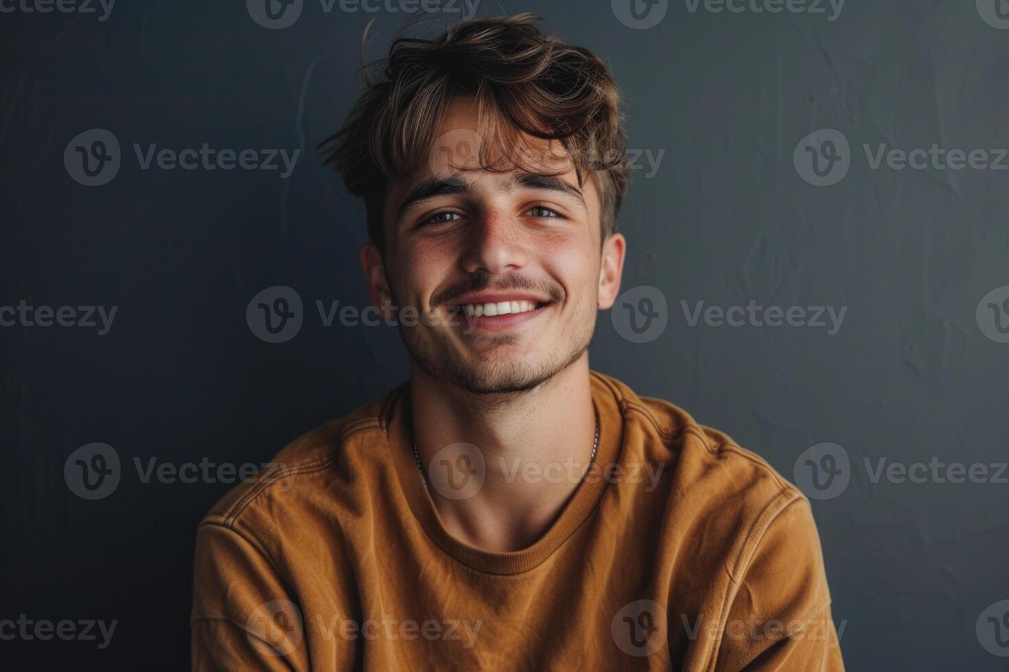 attrayant Jeune homme avec branché coiffure contre gris Contexte. photo