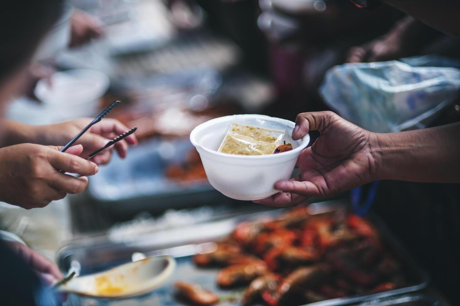 bénévole à servir gratuit nourriture pour le pauvres dans une nourriture don centre charité concept photo