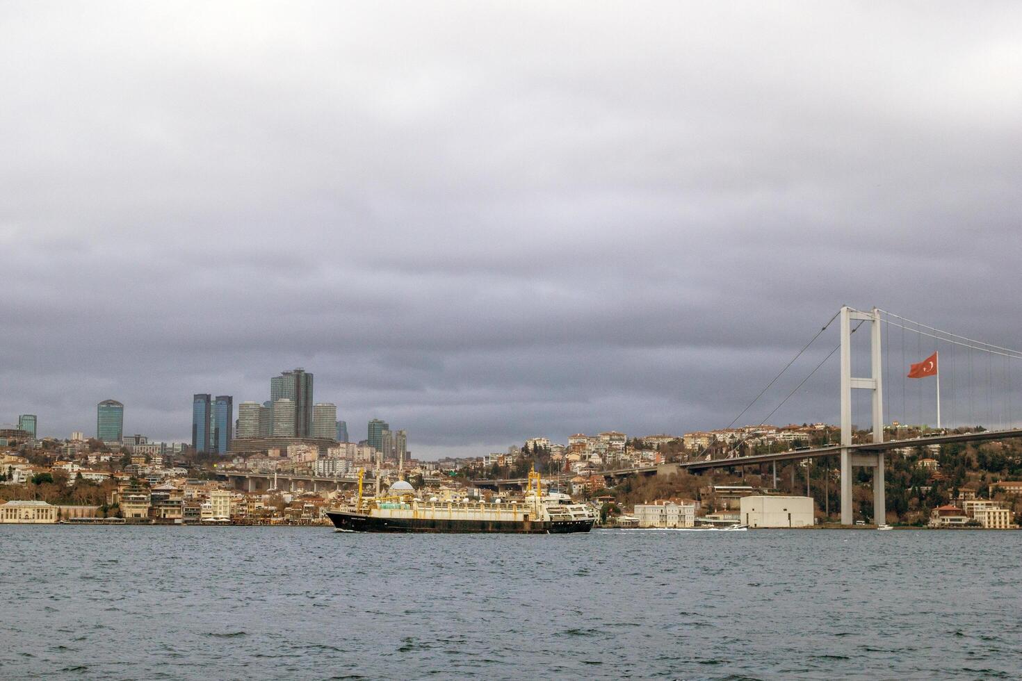 Istanbul, dinde - décembre 28, 2022. impressionnant passager navire voile sur le le bosphore détroit qui passe en dessous de le pont à le coucher du soleil. photo