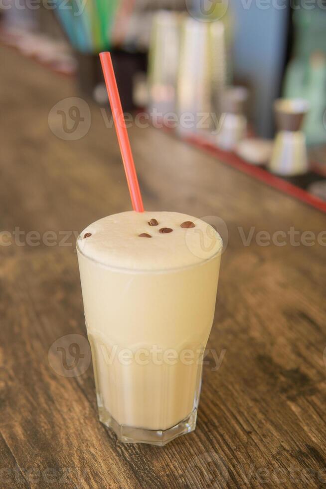 une du froid café cocktail dans une clair verre avec une paille sur une en bois bar compteur photo