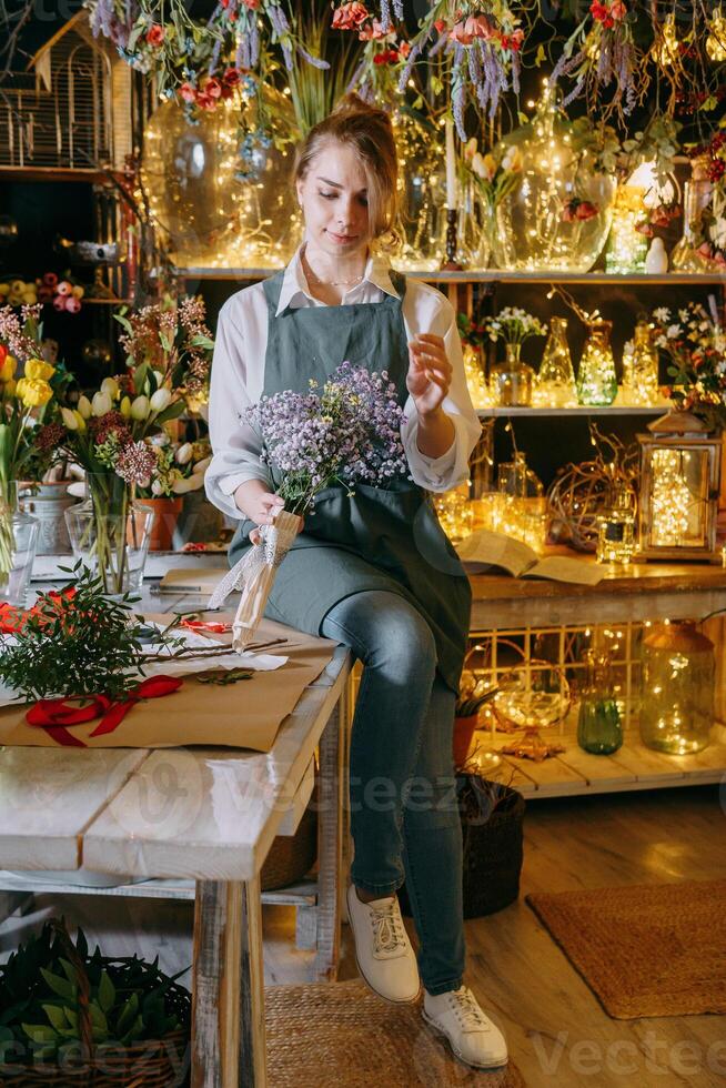 une femme dans sa fleuriste magasin recueille bouquets de fleurs. le concept de une petit entreprise. bouquets de tulipes pour le vacances sur Mars 8. photo