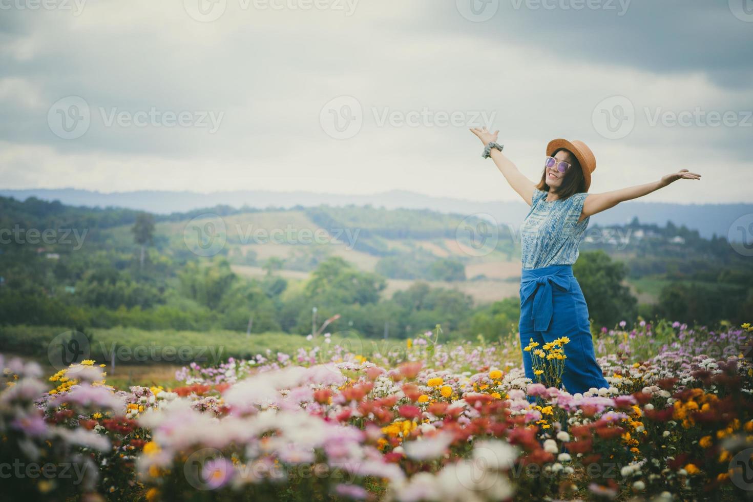 femme heureuse debout dans un beau champ de fleurs en fleurs photo