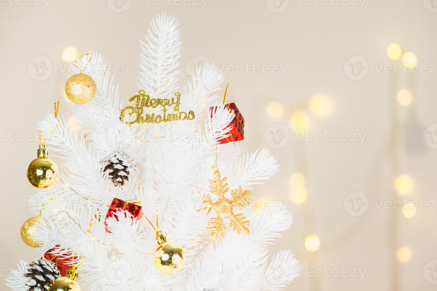 décoration d'arbre de noël blanc avec flocon d'or et pomme de pin boule au bokeh photo