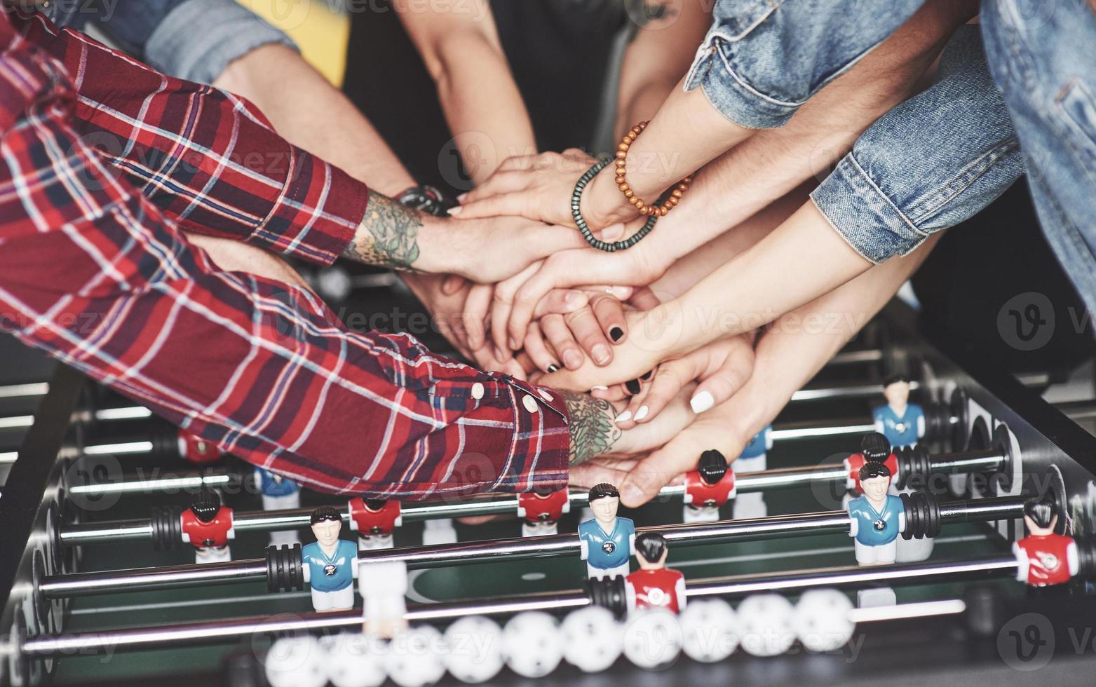 jeunes souriants jouant au baby-foot pendant leurs vacances photo