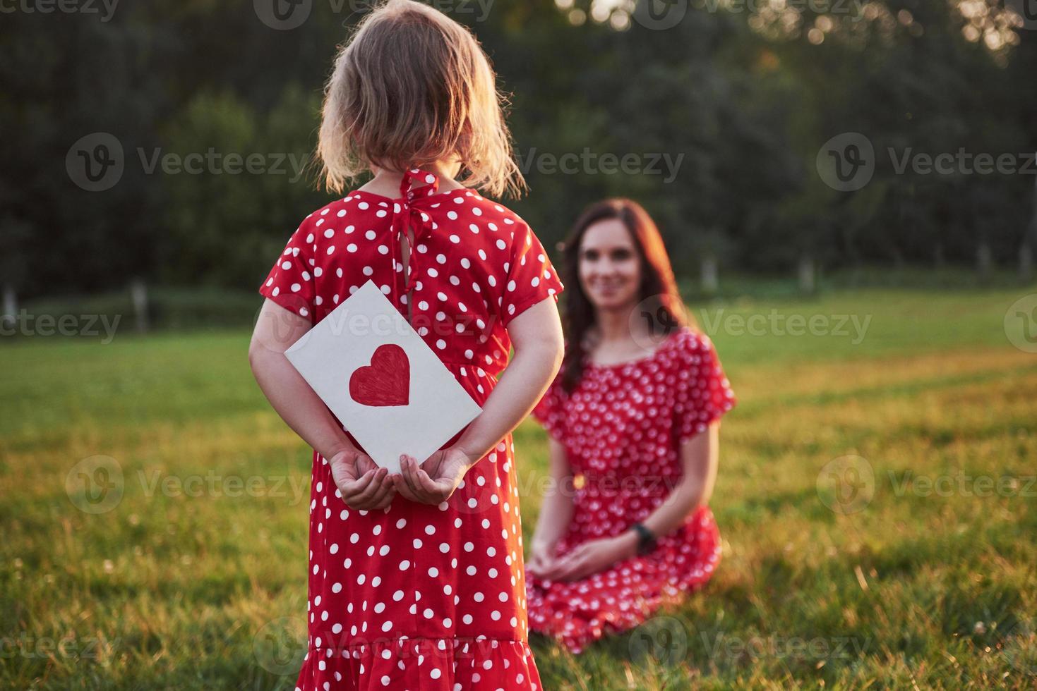 mère joue avec sa fille dans la rue dans le parc au coucher du soleil photo