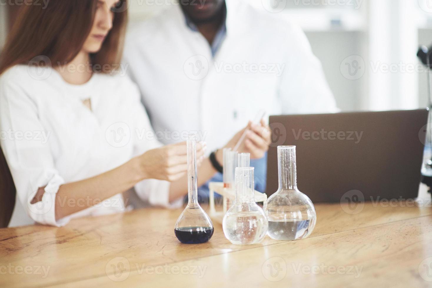 les scientifiques travaillent en étroite collaboration avec le microscope en laboratoire en menant des expériences et des analyses. photo