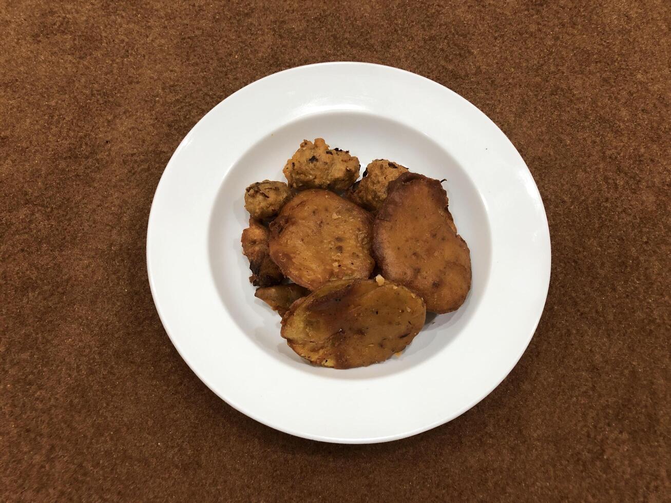 mirchi pakora ou mirchi bhajji servi dans une blanc plaque, une célèbre midi casse-croûte dans Inde, servi plus de une rustique en bois arrière-plan, sélectif concentrer photo