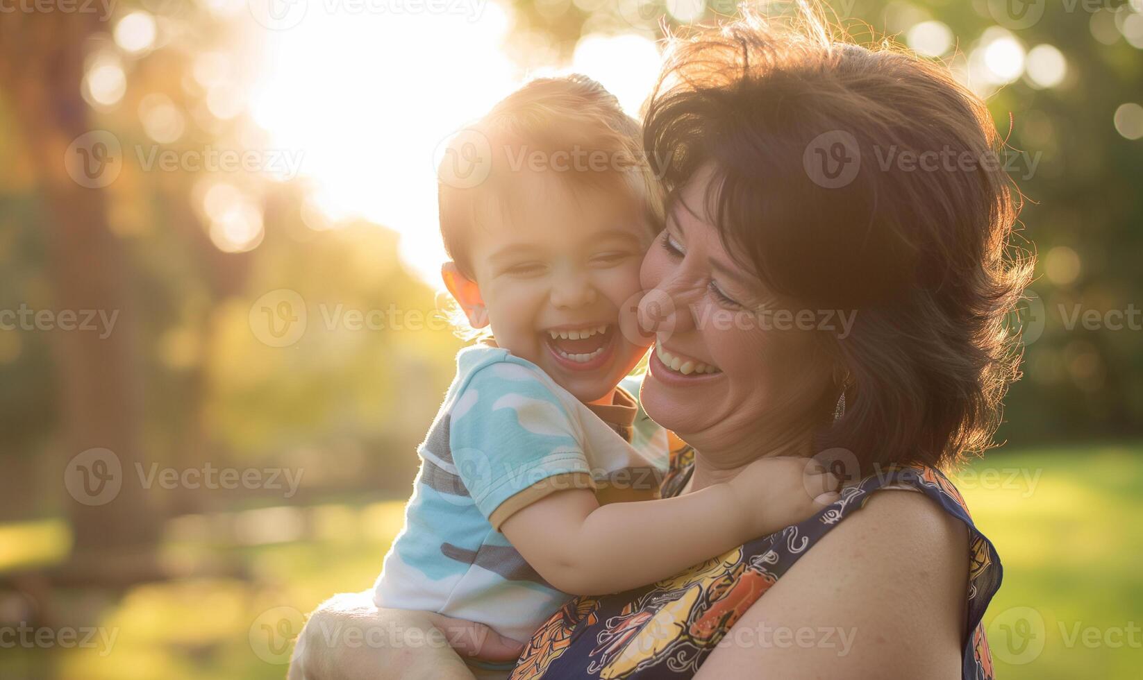 joyeux embrasse mère et fils en riant ensemble dans ensoleillé parc photo