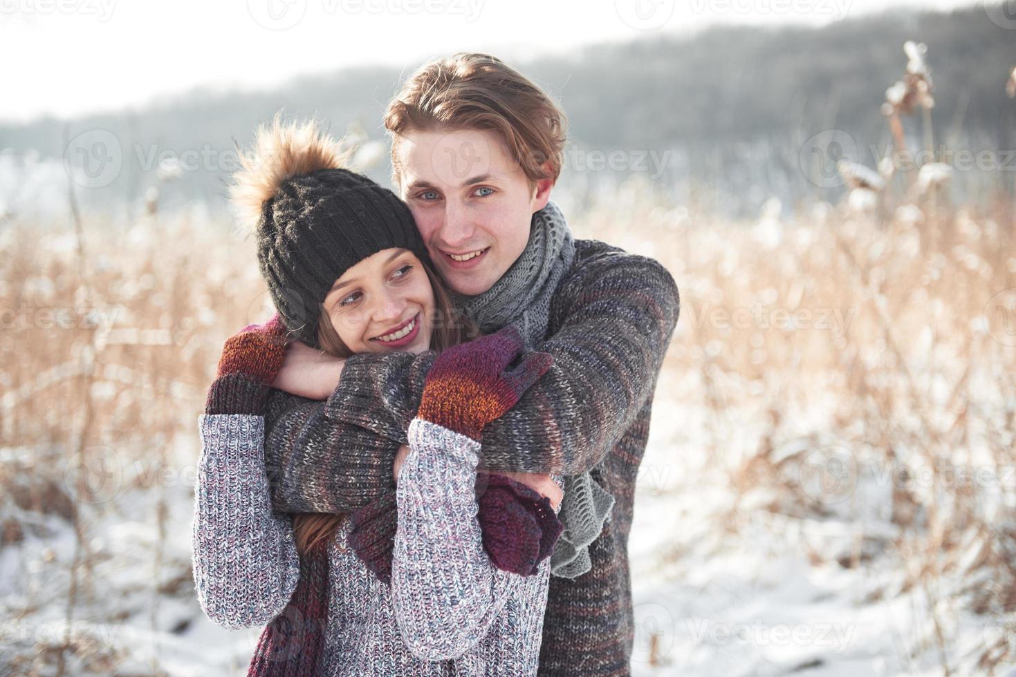 couple heureux de noël amoureux embrasser dans la forêt froide d'hiver enneigé, espace de copie, célébration du nouvel an, vacances et vacances, voyage, amour et relations photo