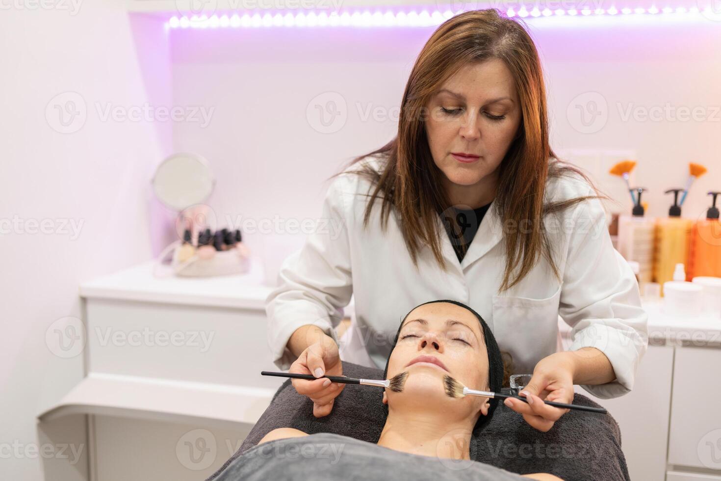 esthéticienne Faire faciale nettoyage pour client dans beauté centre photo