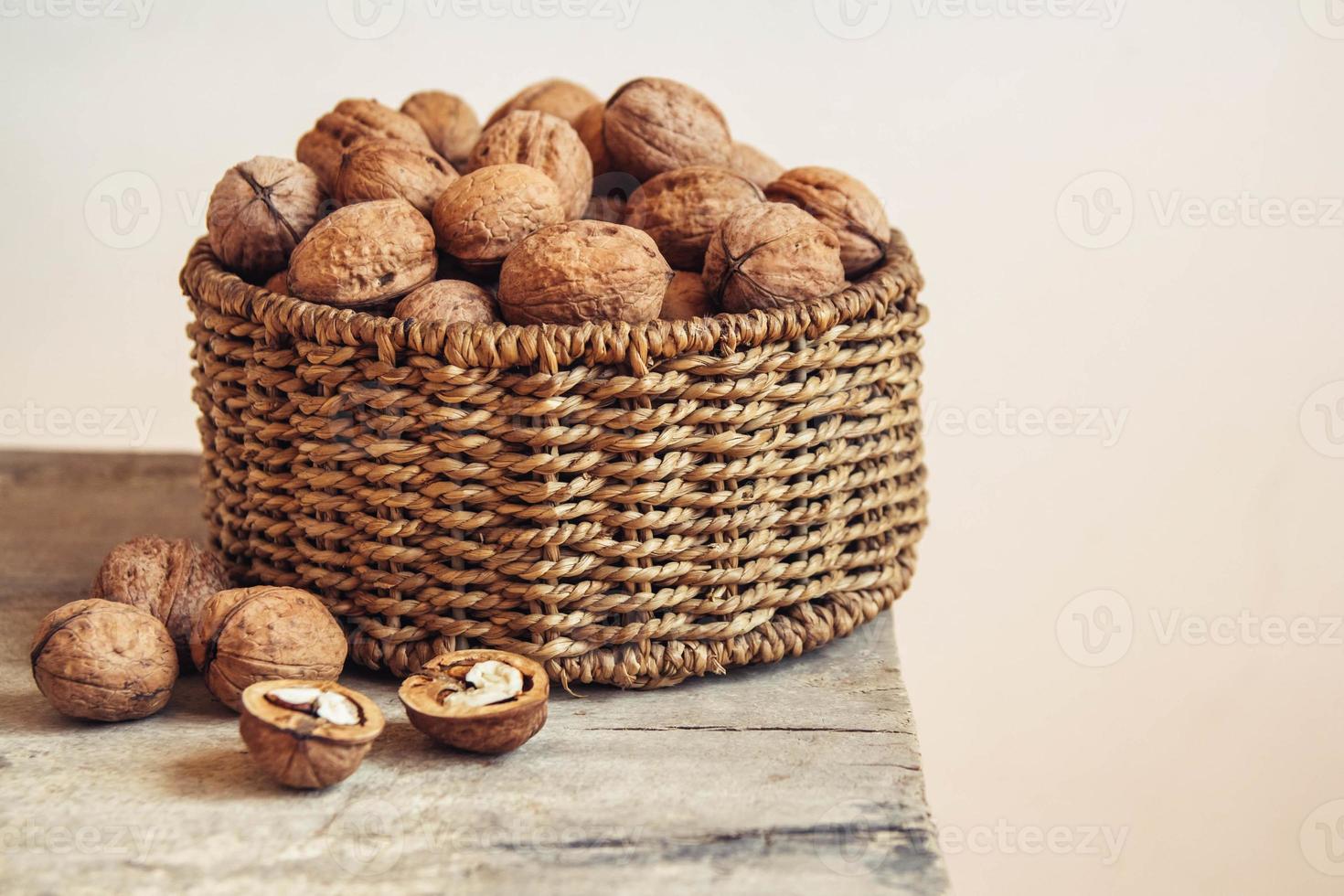 noix dans un panier en osier rond sur un fond en bois photo