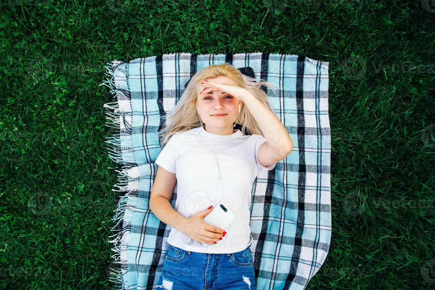 femme dans les écouteurs et smartphonesur fond vert photo