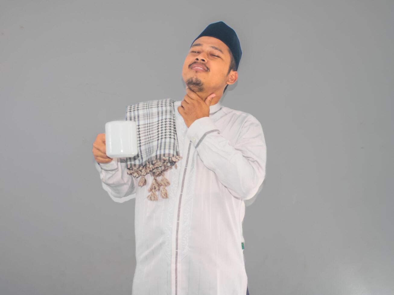 musulman homme en portant une chaud boisson et émouvant le sien gorge montrant soulagé expression photo