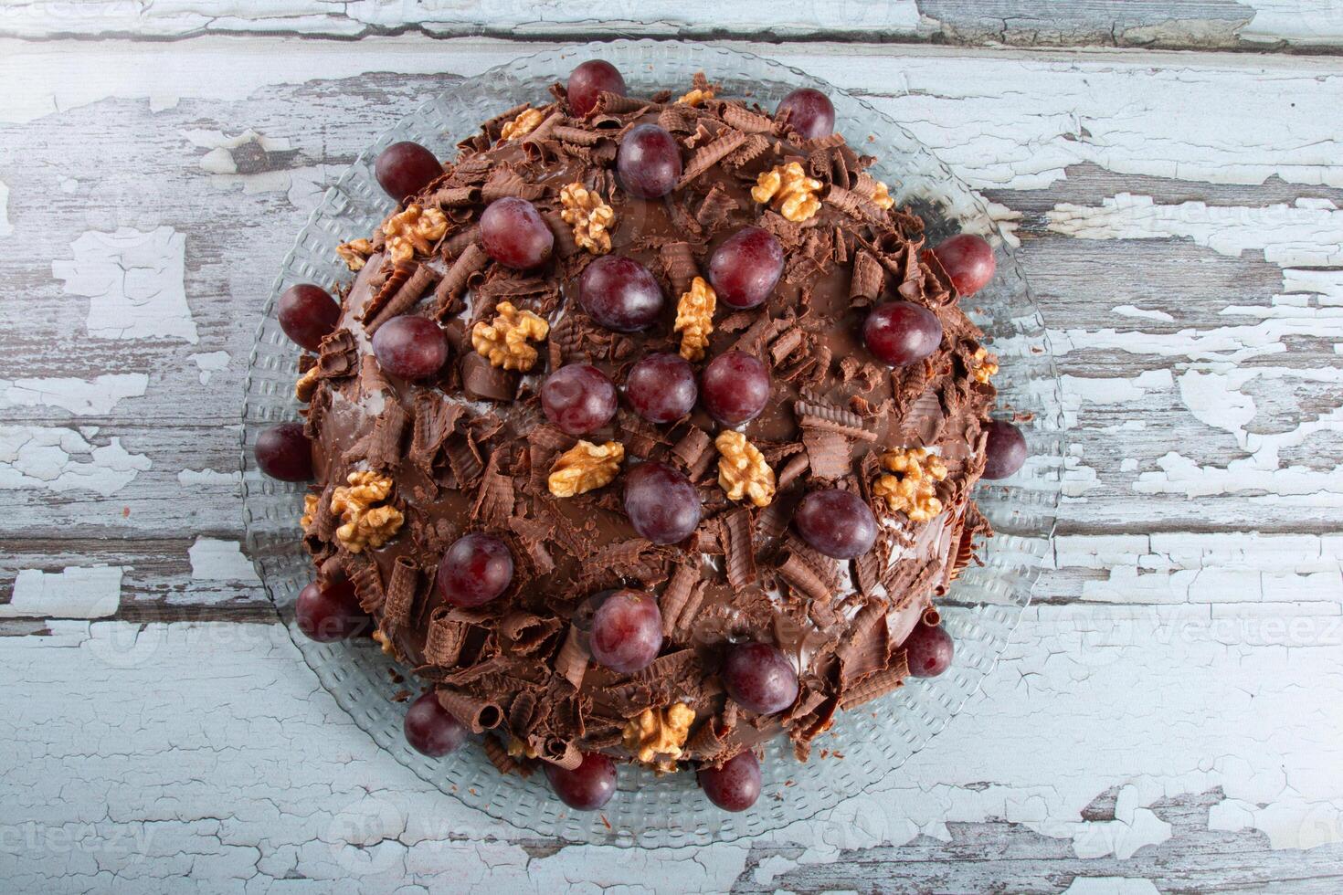 gâteau avec Chocolat glaçage et les raisins sur une rustique Contexte photo