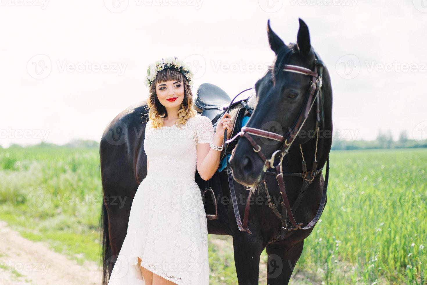 fille aux lèvres rouges près d'un cheval noir photo