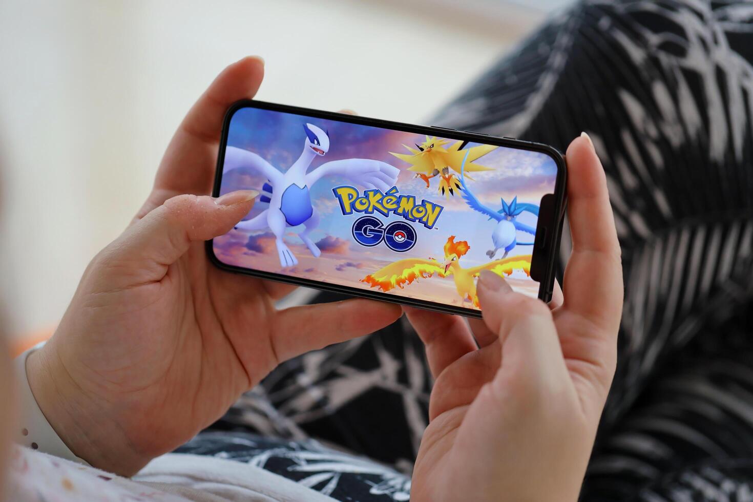 Pokémon aller mobile ios Jeu sur iphone 15 téléphone intelligent écran dans femelle mains pendant mobile gameplay photo