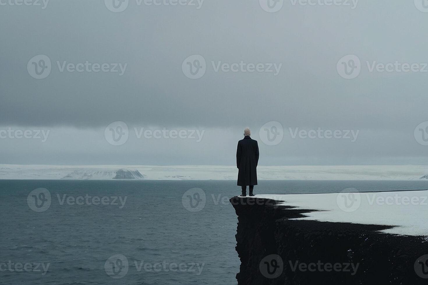 une homme permanent sur le bord de une falaise surplombant le océan photo