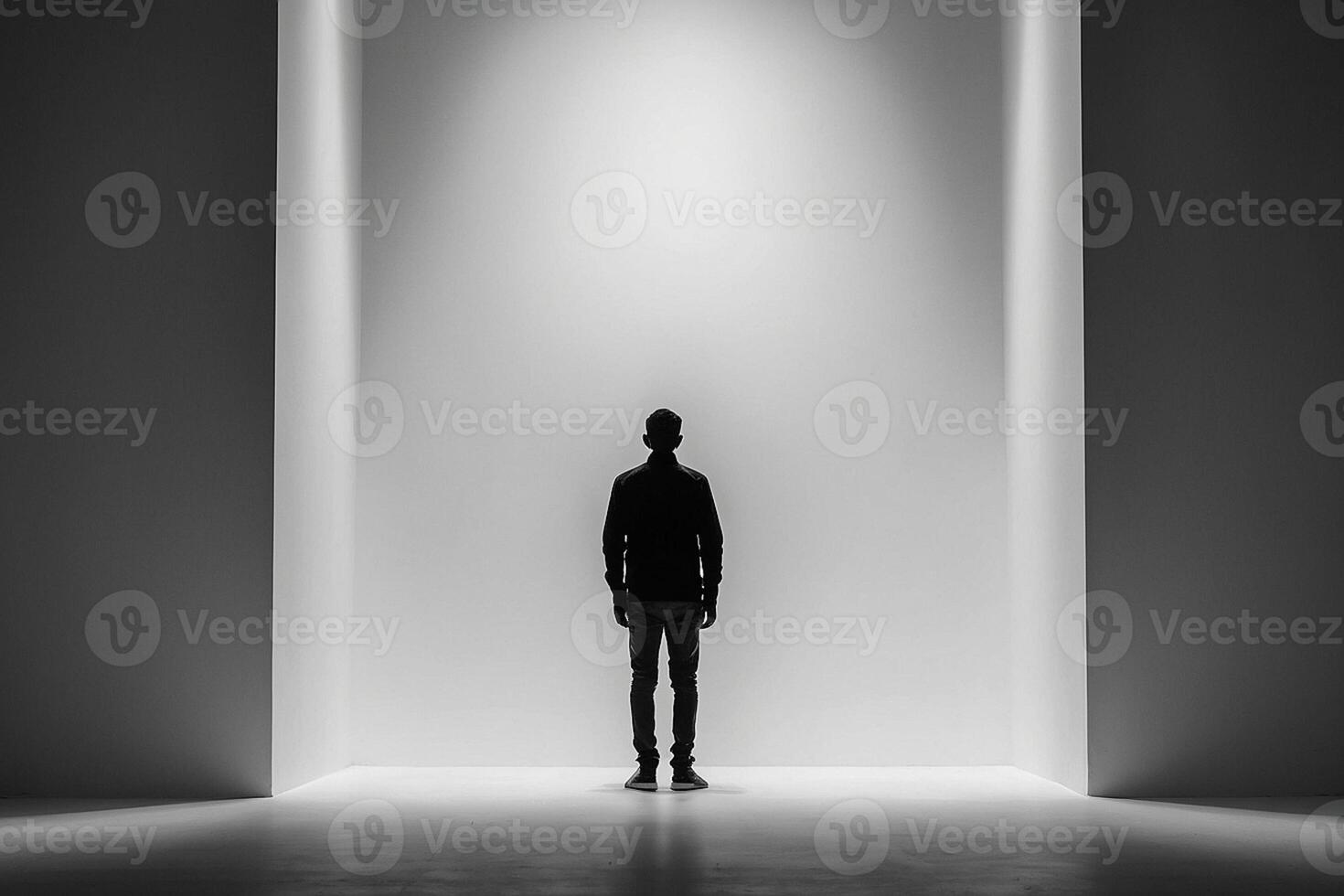 une homme permanent dans de face de une lumière dans une foncé pièce photo