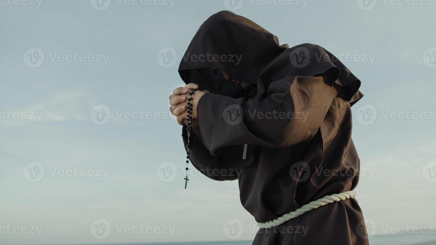 religieux moine prie seul le chapelet crucifix solitaire dans la nature photo