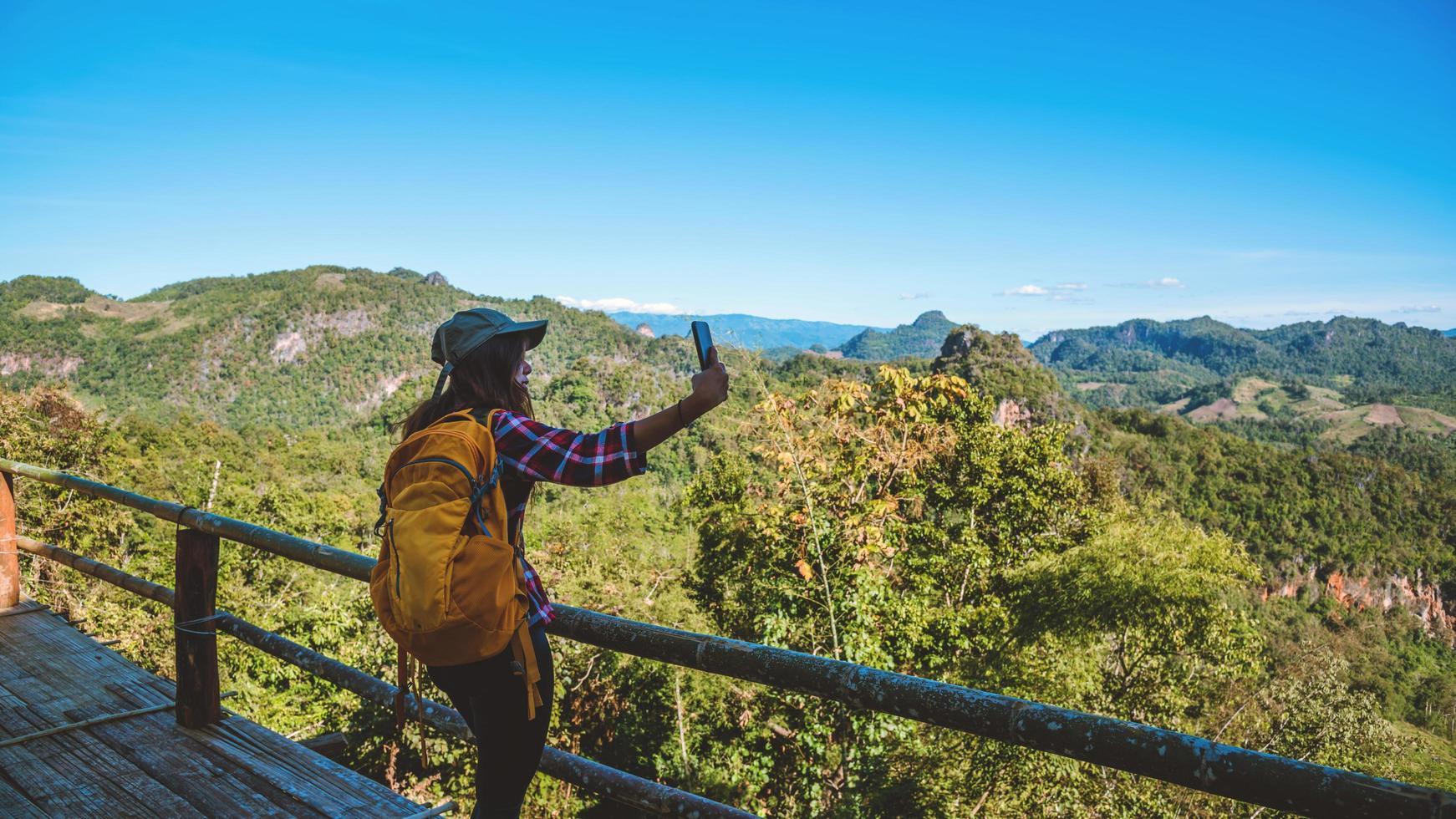 la femme debout au point de vue. profitez de photographier la beauté naturelle des montagnes. photo