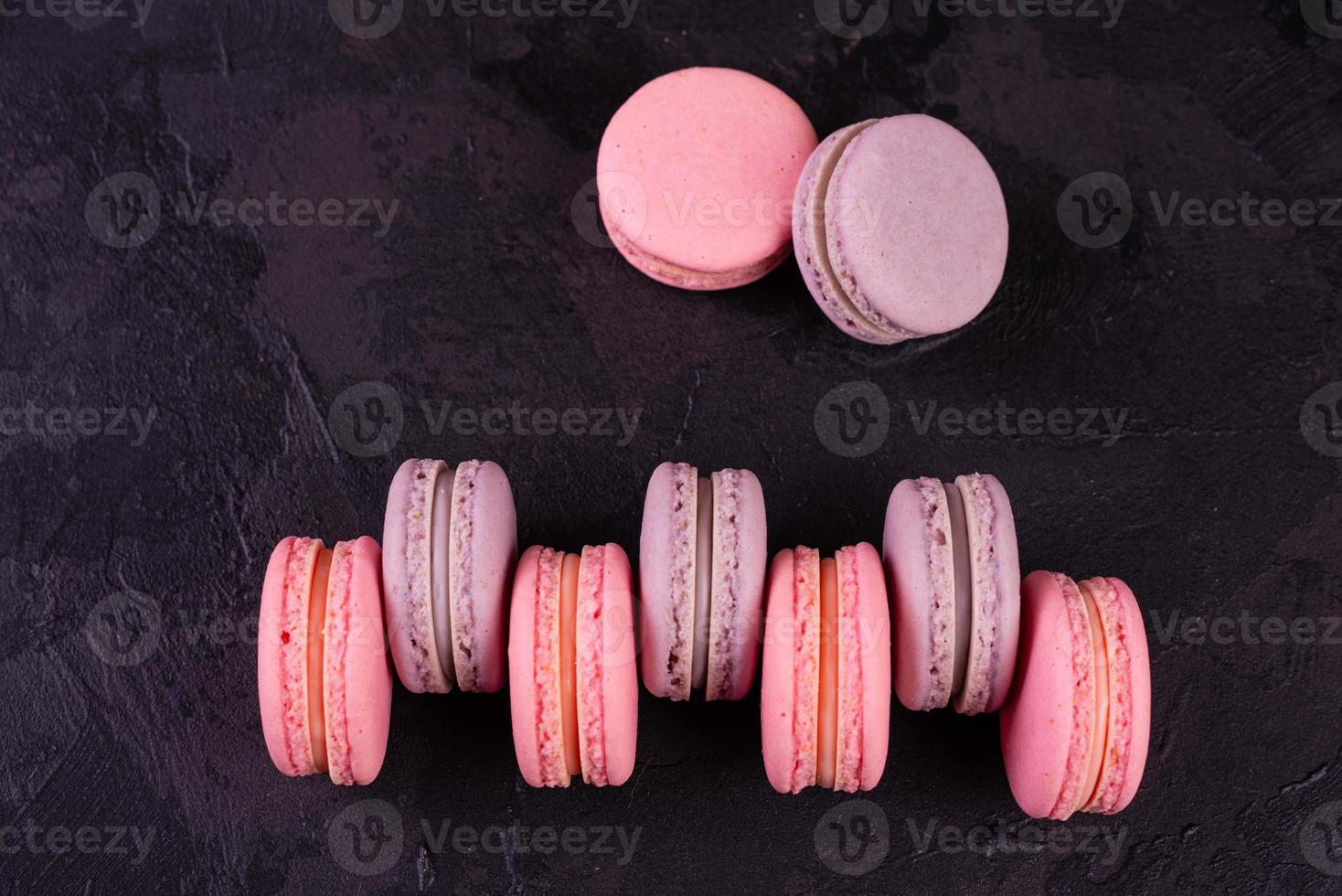 beaux macarons savoureux roses sur fond de béton photo