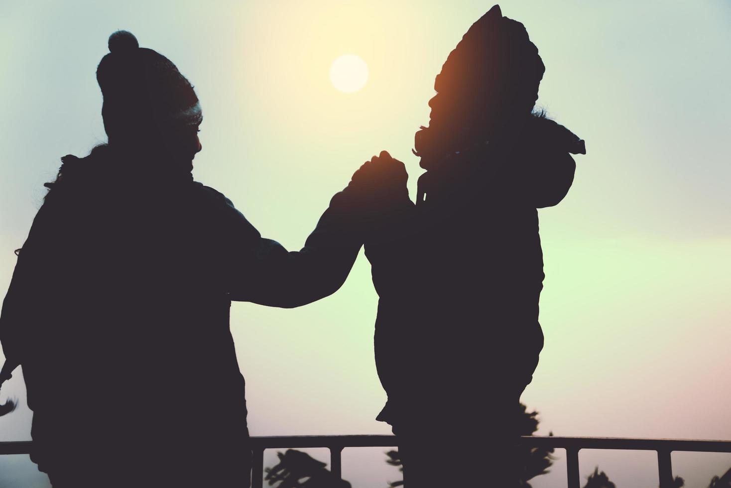 amoureux des femmes et des hommes asiatiques voyagent se détendre pendant les vacances. se lever pour le lever du soleil sur la montagne. en hiver. en Thaïlande photo